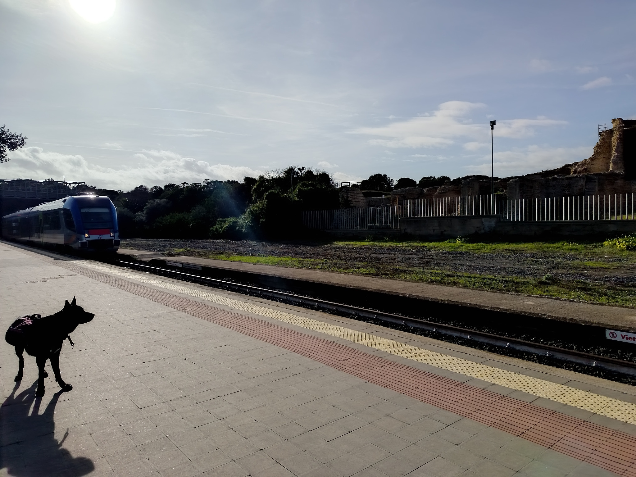Mia wearing her backpack while waiting beside a railway platform in Sardinia